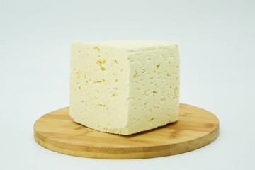 Milk cheese on a wooden board. The product is ready to use. White background.