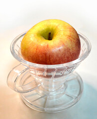 Image of a red apple on a dripping cup on a white background.