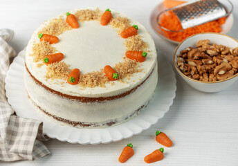 Homemade carrot cake made with walnuts, iced with cream cheese. Sweet dessert.