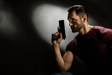 Portrait of focused bearded secret agent keeping gun and aiming, A powerful presence: Dark and...
