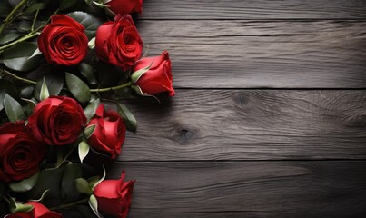 A bunch of vibrant red roses resting on top of a sturdy wooden table.