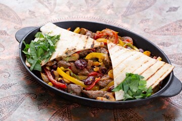 Popular Tex-Mex dish made from grilled meat, usually beef or chicken, which is served on a sizzling hot skillet along with grilled onions and peppers and warm tortilla bread