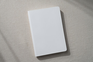 top view blank white book cover mockup on earthy neutral colors cloth background. with clipping path.