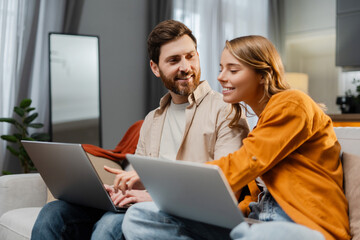 Busy smiling man and woman, freelancers using laptop, planning project, startup, working at home