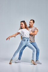 kizomba or bachata or semba or taraxia dancers in casual clothes on rehearsal, training together in studio on bright white background. The grace, artist, movement, action and motion concept.