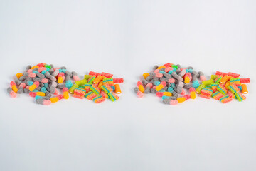 Sour tasting colorful gummy worms as line on white background