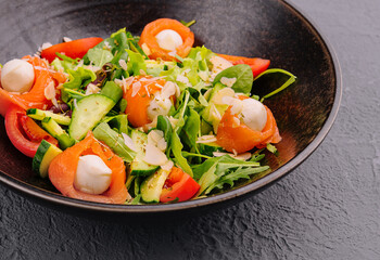 Salmon salad with mozzarella, tomato, cucumber on bowl