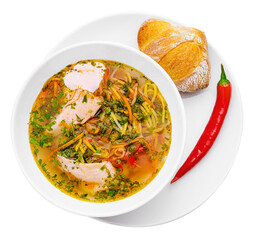 Chicken soup with noodles and vegetables in white bowl