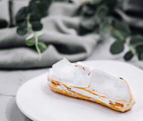 eclair with meringue on plate close up