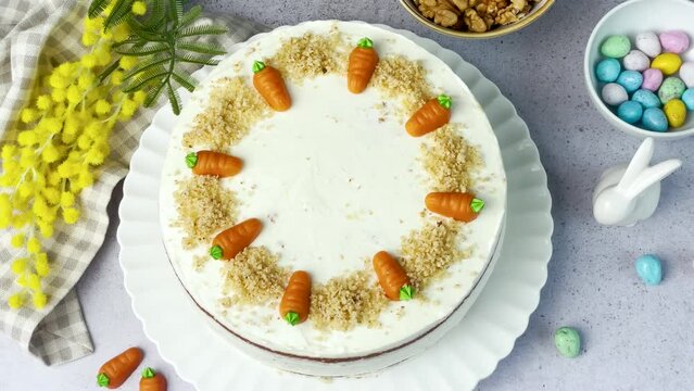 Homemade Easter carrot cake made with walnuts, iced with cream cheese. Sweet dessert.  Plate with delicious carrot cake