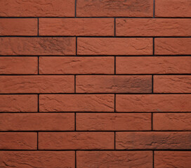 Stone cladding wall made of striped stacked slabs of red and orange rocks. Panels for exterior. Background and texture.