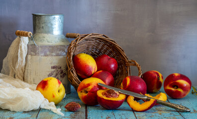 Ripe and juicy nectarines rolled out of the basket onto the table. Knife and cut fruit. Delicious and healthy food.