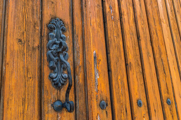 Old wrought iron handle on a wooden gate