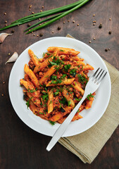 Traditional Italian cuisine: tasty pasta with bolognese sauce. Delicious macaroni (penne rigate) on rough wooden table. Top view