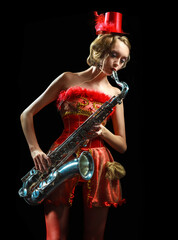 Woman in red dress with saxophone at the black background