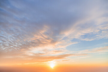 A beautiful sky tinted by the sun leaving vibrant shades of gold, pink, blue and multicolored. Clouds in the twilight evening and morning sky. Cloudy sky background in the evening and during the day.