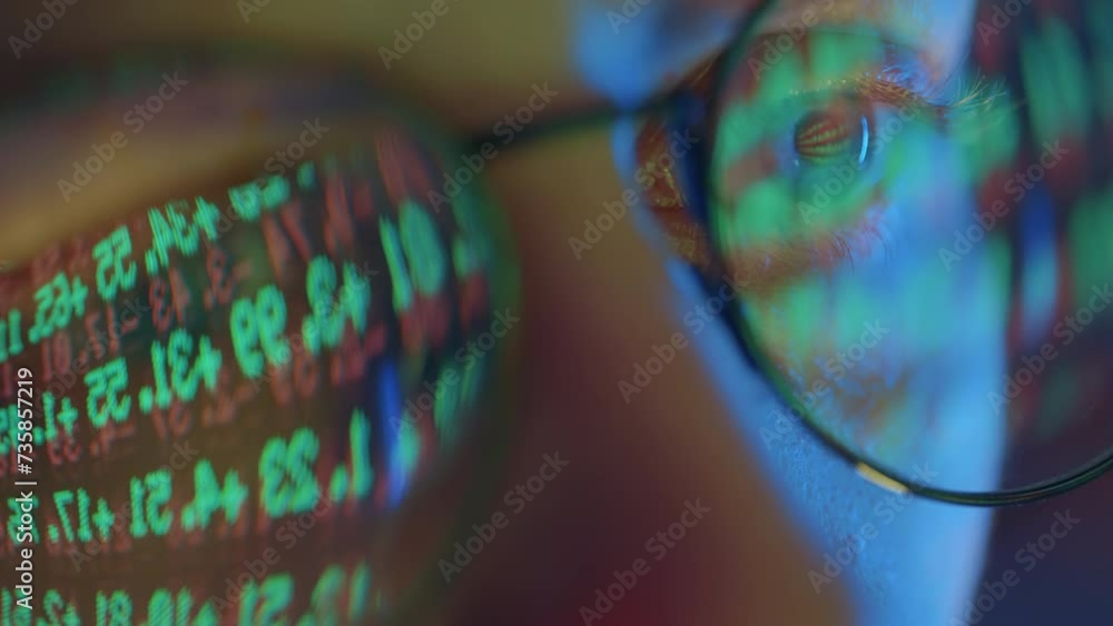Poster trader wearing glasses is working on laptop computer. screen with stock market charts and bitcoin bt