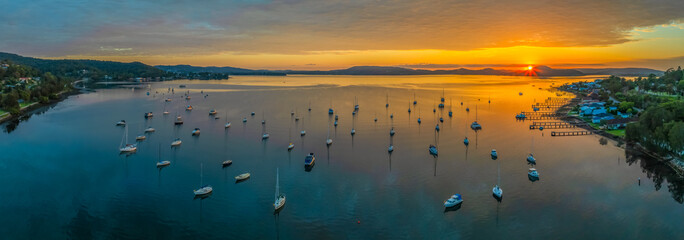 Aerial sunrise over the water with boats and clouds - Powered by Adobe