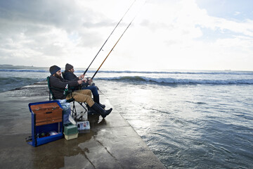 Friends, fisherman and men by ocean fishing with rod, reel and equipment to catch fish for hobby....