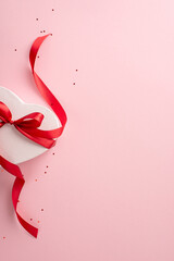 Lovely feminine present idea: top view vertical image of a heart-shaped present tied with a red...