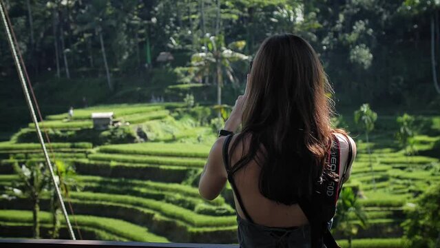 High definition slow motion footage of woman taking a photo with her mobile phone at Tegallalang rice terraces in Bali, Indonesia.
Medium angle, parallax movement.