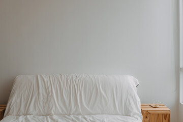 A comfortable white couch is placed against a white wall in a beautifully designed interior with...