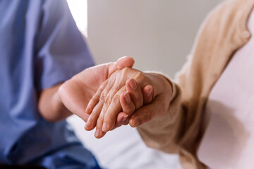 Close-up senior Asian woman hand with her caregiver helping hands, Caregiver visit at home. Home...