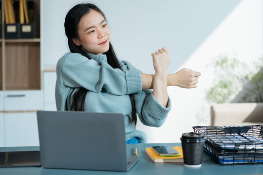 Asian woman relaxing at comfortable office chair hands behind head Happy woman resting in the office with satisfaction after work Enjoy a break with your eyes closed. peace of mind no stress.