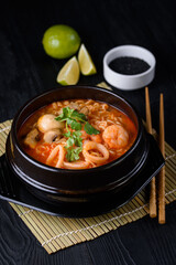 Korean food. seafood soup, salmon, eel, shrimp. on a black wooden background.