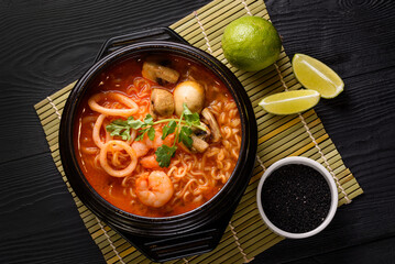 Korean food. seafood soup, salmon, eel, shrimp. on a black wooden background.