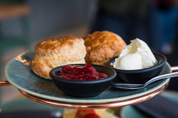 English scones on a plate in bakery with jam and clotted cream
