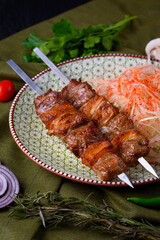 beef lump kebab with onions in a plate on a green cloth