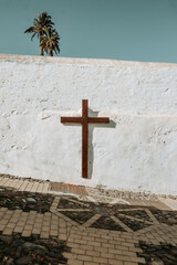 Drewniany krzyż na pobielanym murze w Telde na wyspie Gran Canaria - obrazy, fototapety, plakaty