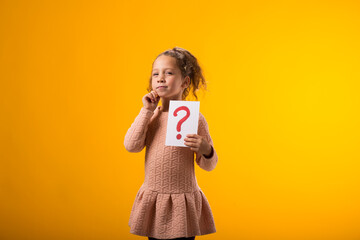 Thoughtful kid girl holding question mark card. Children, idea and knowledge concept