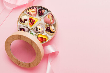 Holiday composition: sweet candy, with gift boxes with bow and chocolate hearts, photo template, background. Top View with copy space on colored background