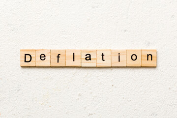 deflation word written on wood block. deflation text on table, concept