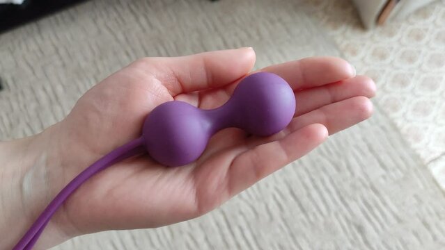 Young woman holds a dildo in her hand