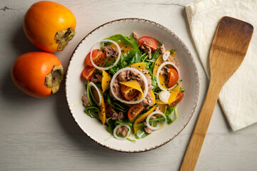 Persimmon, tomato, onion and tuna salad.