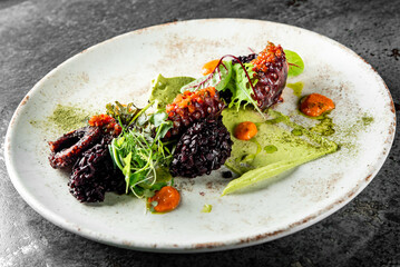 Cooked octopus and black rice in plate