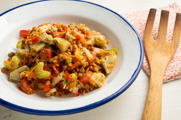 Lentil salad with tomato, onion and artichokes.