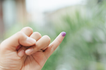 Indonesian man showing little finger covered with ink after giving vote on election or Pemilu