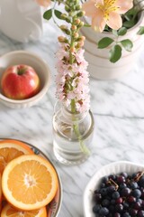 A table adorned with various plates filled with an assortment of ripe fruits and vibrant flowers.