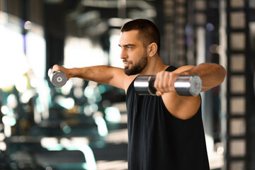 Young Muscular Man Doing Dumbbell Lateral Raise Exercise At Gym - obrazy, fototapety, plakaty