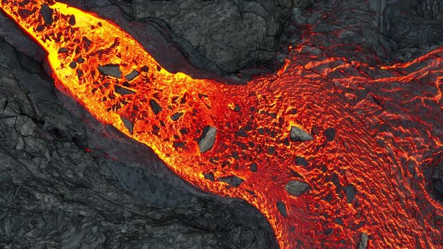 Aerial drone view over river of molten hot lava erupting from the Litli-Hrútur Iceland volcano and flows through dark rock in 2023. Tourist attraction to beautiful and dangerous disaster.
