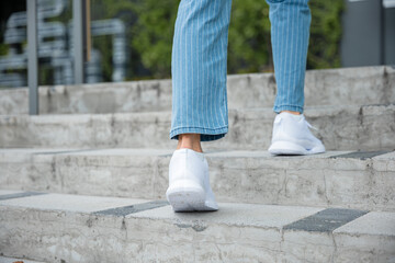 A businesswoman in sneakers conquers the city stairs, symbolizing her determined path. Each step...