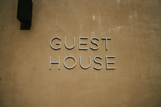 Letrero de neón que dice Guest House en una pared de color amarillento.
Señal de salida iluminada, con tipografía moderna.