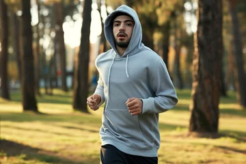 Keuken spatwand met foto man jogging in park wearing a gray hooded sweatshirt © primopiano