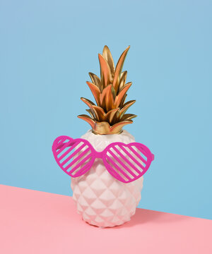 Pink heart shaped glasses and decorative luxe pineapple. Party composition.