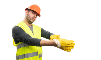 Serious constructor man getting ready for work putting gloves on