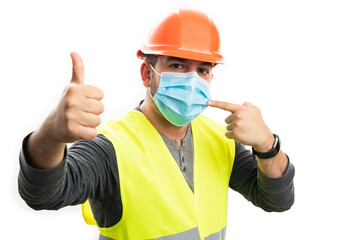 Builder making like gesture pointing at surgical or medical mask